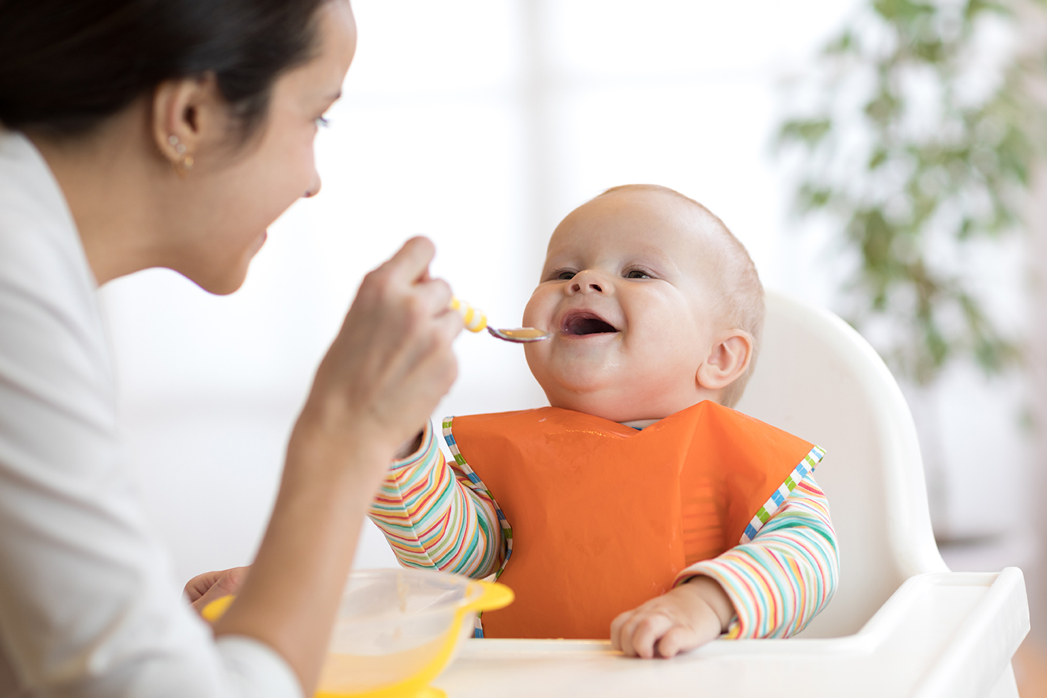 Để giúp bé phát triển thính giác, trong khi cho bé ăn dặm mẹ hãy tích cực trò chuyện với bé.